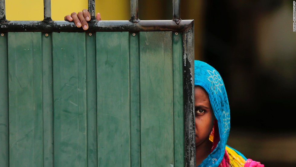 A Sri Lankan Muslim woman looks out on the street, in Aluthgama, town, 50 kilometers (31.25 miles) south of Colombo, Sri Lanka, Monday, June 16, 2014. At least three Muslims were killed after a right-wing Buddhist group with alleged state backing clashed with Muslims in southwestern Sri Lanka, a government minister said Monday. Dozens of shops were burned, homes looted and some mosques attacked in the violence Sunday night in the town of Aluthgama, local residents said. (AP Photo/Eranga Jayawardena)