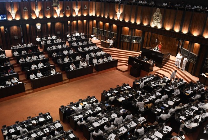 Members of the Sri Lankan parliament gather in the assembly hall in Colombo on November 14, 2018, as a majorty voted to pass a motion of no-confidence in the controversially appointed government of Mahinda Rajapakse. - Speaker Karu Jayasuriya ruled November 14 that a majority of the 225-member assembly supported the motion against Rajapakse who was made prime minister on October 26 in place of Ranil Wickremesinghe. (Photo by LAKRUWAN WANNIARACHCHI / AFP)