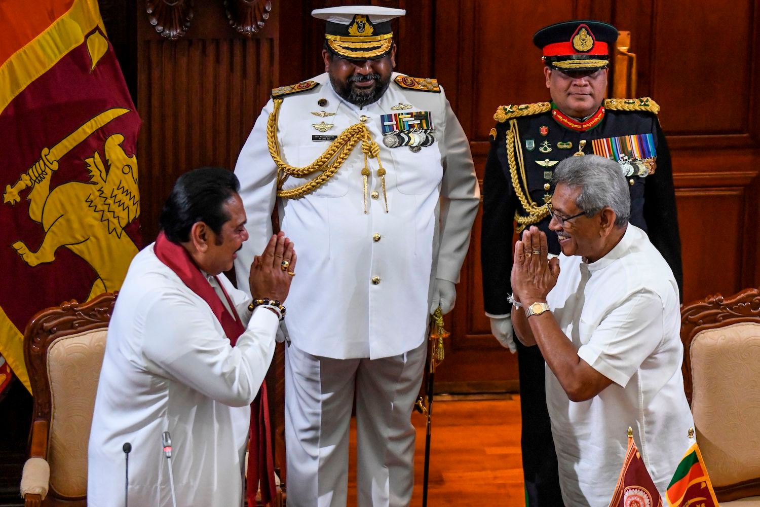 Sri Lanka's former president Mahinda Rajapaksa (L) gestures after taking oath as country's Prime Minister towards his brother, President Gotabaya Rajapaksa (R) during a ceremony in Colombo on November 21, 2019. - Newly elected Sri Lankan President Gotabaya Rajapaksa on November 20 named his brother Mahinda as Prime Minister, cementing the grip on power of a clan credited with brutally crushing the Tamil Tigers a decade ago. (Photo by LAKRUWAN WANNIARACHCHI / AFP) (Photo by LAKRUWAN WANNIARACHCHI/AFP via Getty Images)