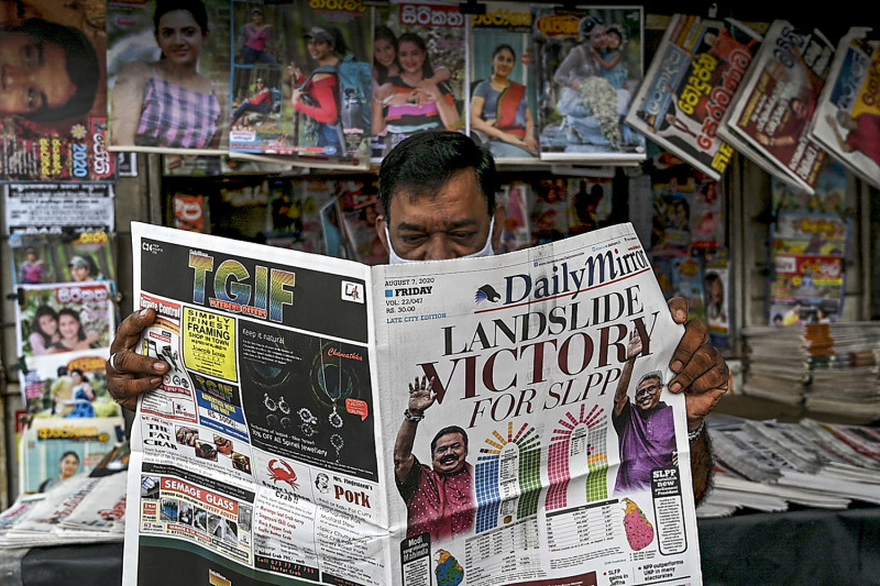 A man reads a local newspaper covering the results of Sri Lanka's parliamentary elections in Colombo on August 7, 2020. - Sri Lanka's ruling Rajapaksa brothers have secured a two-thirds majority in parliamentary elections, giving them powers to change the constitution and unravel democratic safeguards, final results showed on August 7. (Photo by ISHARA S. KODIKARA / AFP) (Photo by ISHARA S. KODIKARA/AFP via Getty Images)