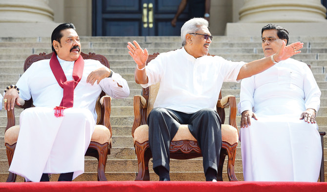 Sri Lanka's new President Gotabaya Rajapaksa (C) and his Prime Minister brother Mahinda Rajapaksa (L), sit for a group photograph after the ministerial swearing-in ceremony in Colombo on November 22, 2019. Sri Lanka's new president announced holding parliamentary elections six months ahead of schedule after giving key portfolios of finance to his prime minister brother Mahinda Rajapaksa. / AFP / ISHARA S. KODIKARA